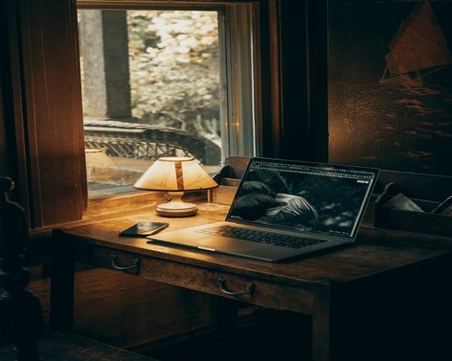 A student participating in online university classes with a dedicated soft desk lamp