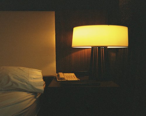 Warm ambient lamp next to a book on a nightstand before sleep